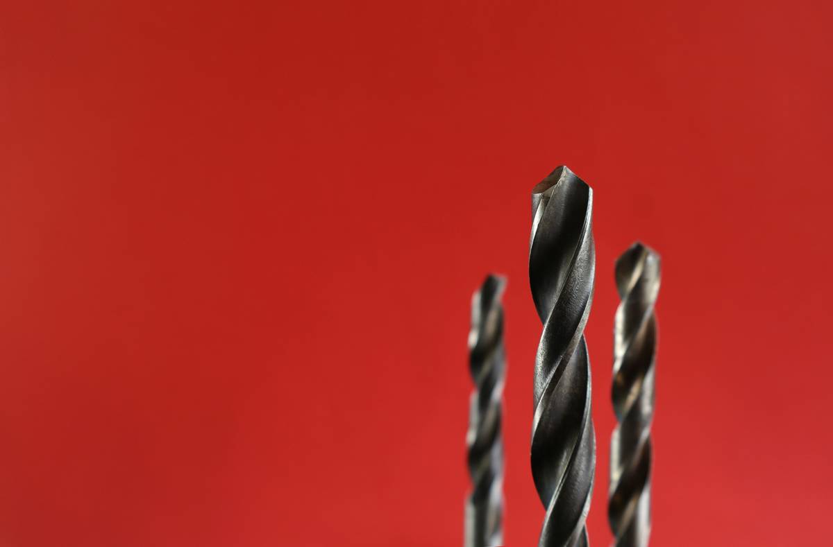 Comparison chart of drill bits for wood, metal, masonry, and tile showing tip geometry, flute design, and recommended materials
