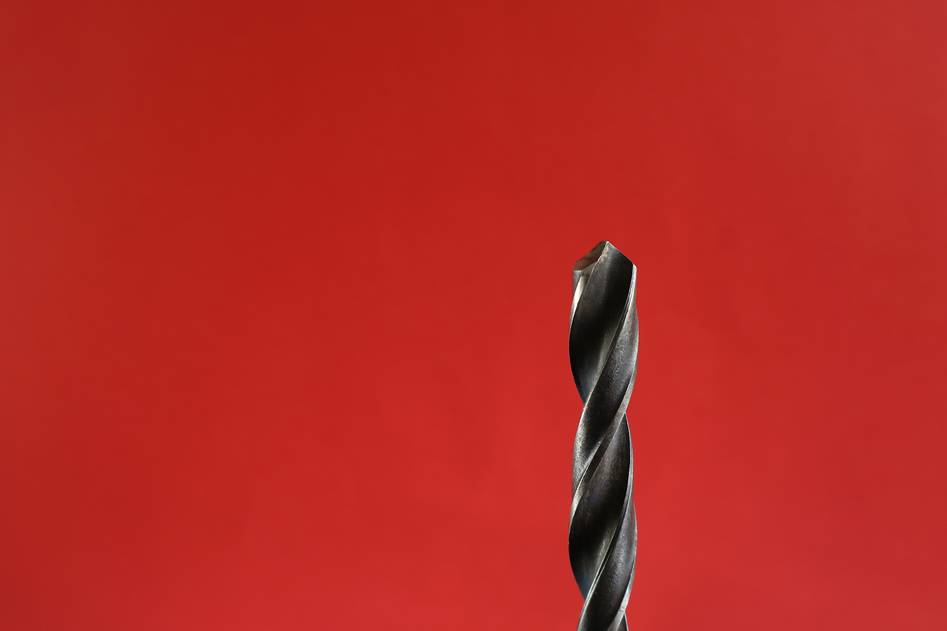 Team testing various drill bits in a workshop setting
