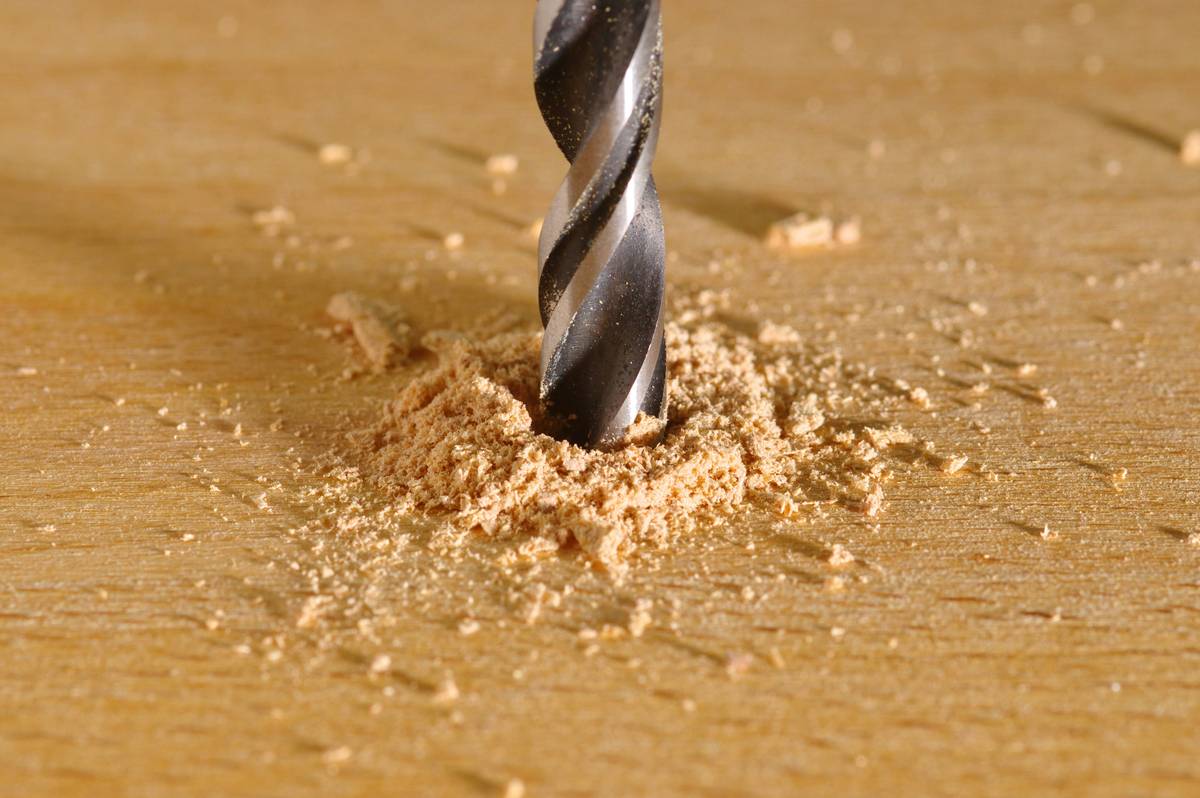 DIY expert using woodworking bits and hole drills for precise cabinetry